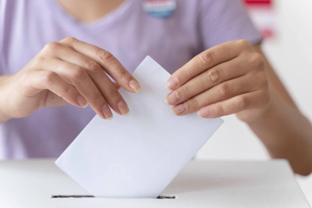 Personne glissant son bulletin de vote dans l'urne